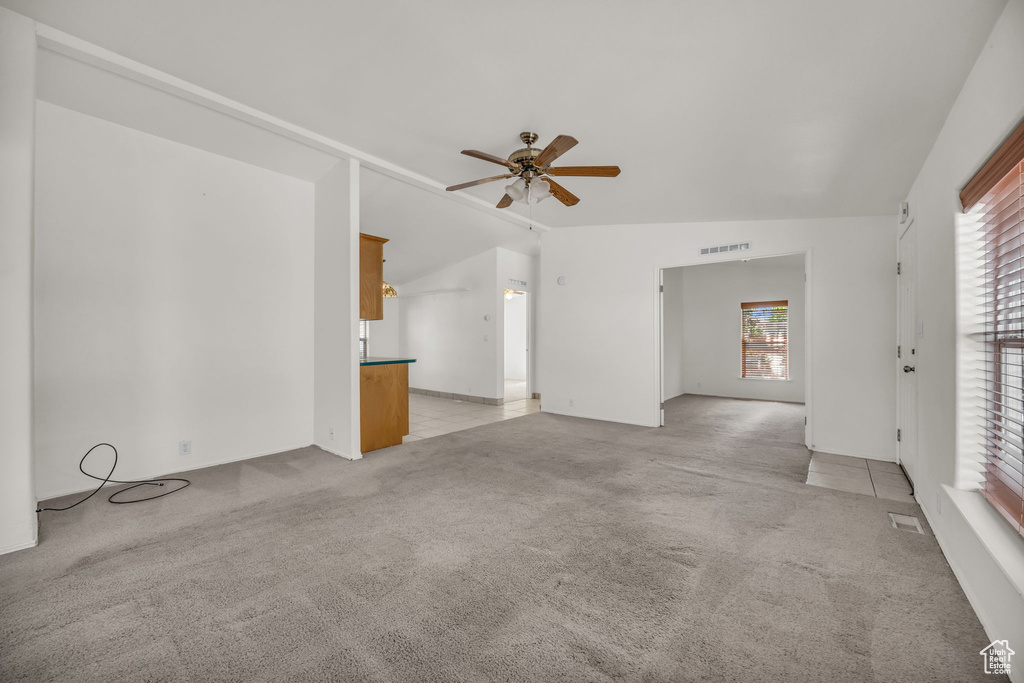 Unfurnished living room featuring light carpet and ceiling fan