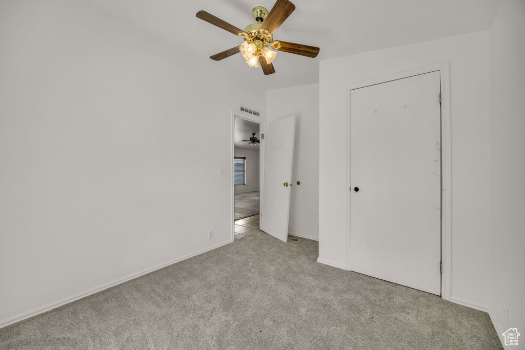 Unfurnished bedroom with carpet flooring, a ceiling fan, and baseboards