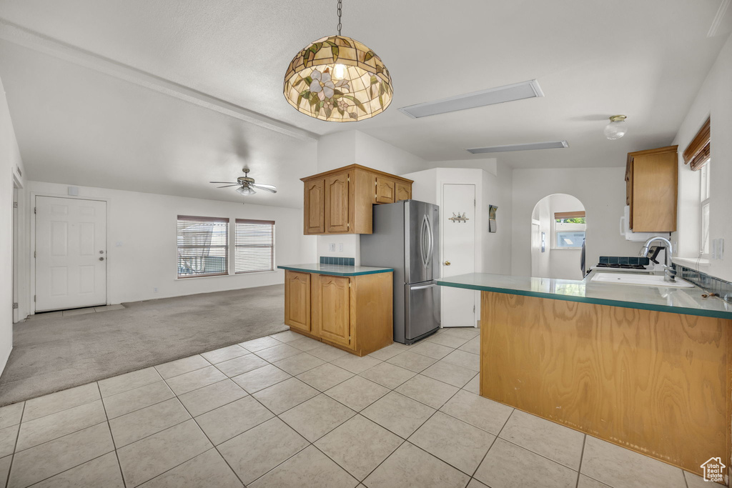 Kitchen with freestanding refrigerator, light colored carpet, plenty of natural light, and light tile patterned floors