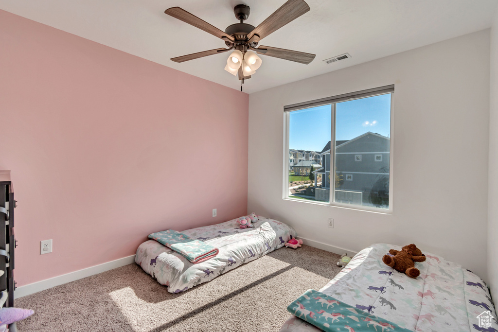Carpeted bedroom with baseboards and a ceiling fan