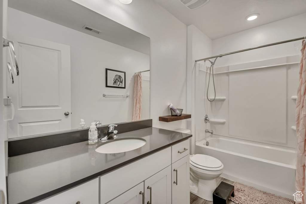 Bathroom with toilet, vanity, shower / bath combo, and recessed lighting