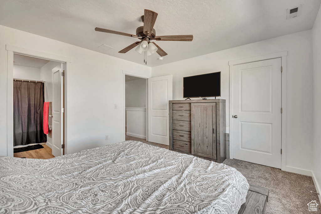 Carpeted bedroom with a ceiling fan and baseboards