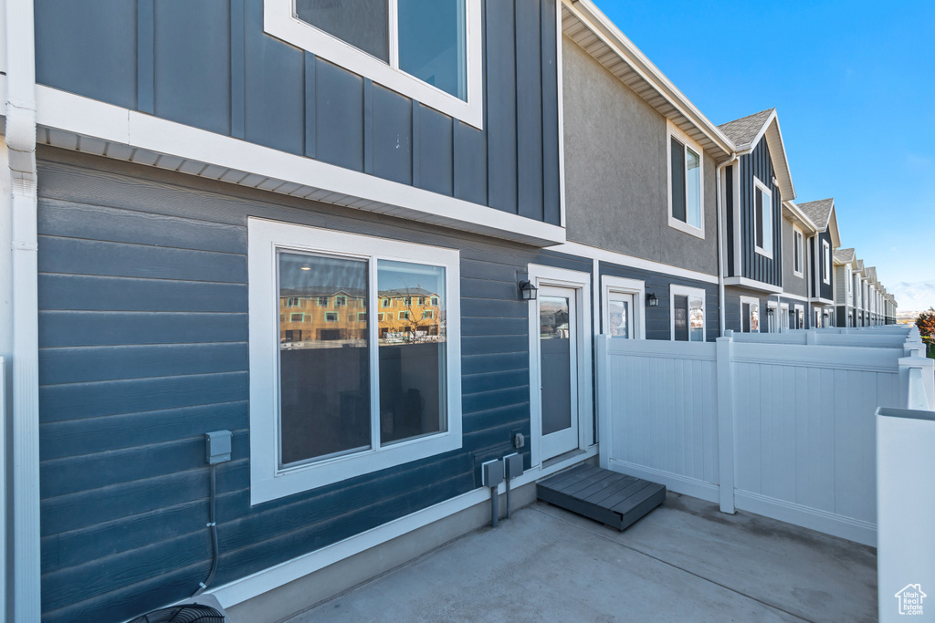 View of property exterior featuring fence, a patio, and board and batten siding