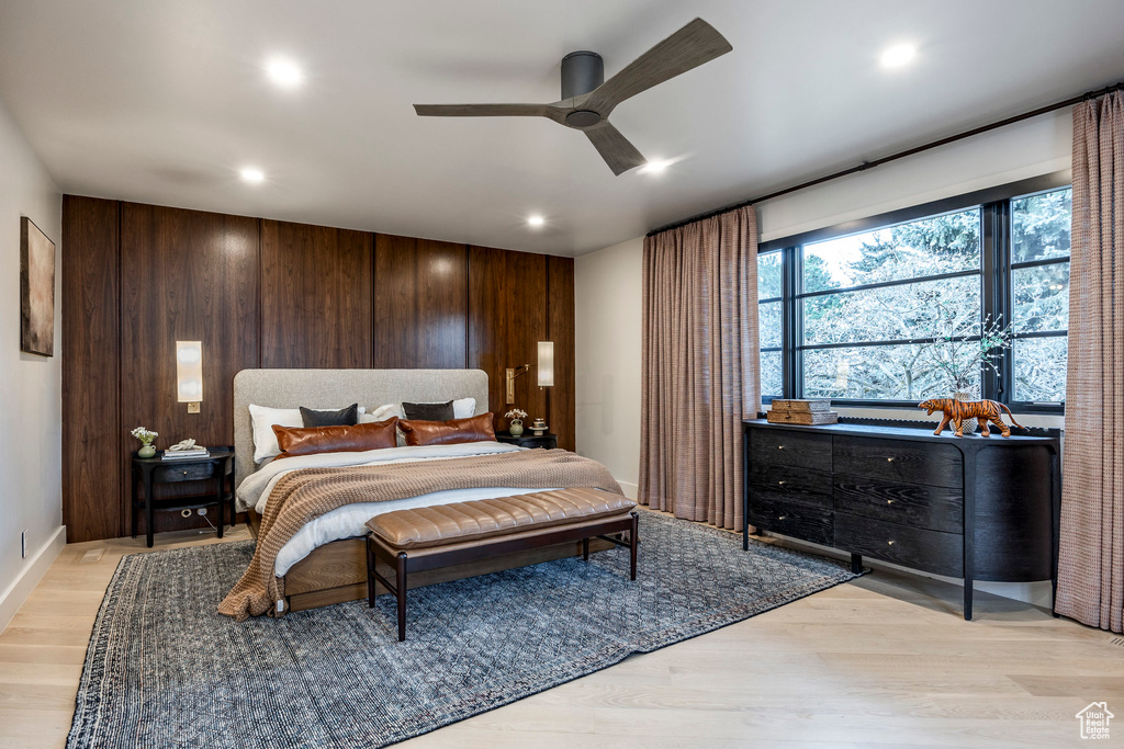 Bedroom featuring recessed lighting, light wood finished floors, wooden walls, a ceiling fan, and baseboards