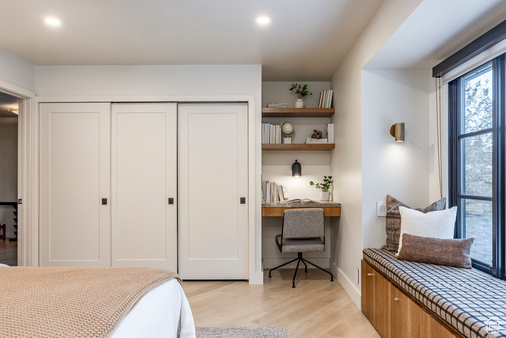 Bedroom featuring light wood-type flooring, a closet, and baseboards