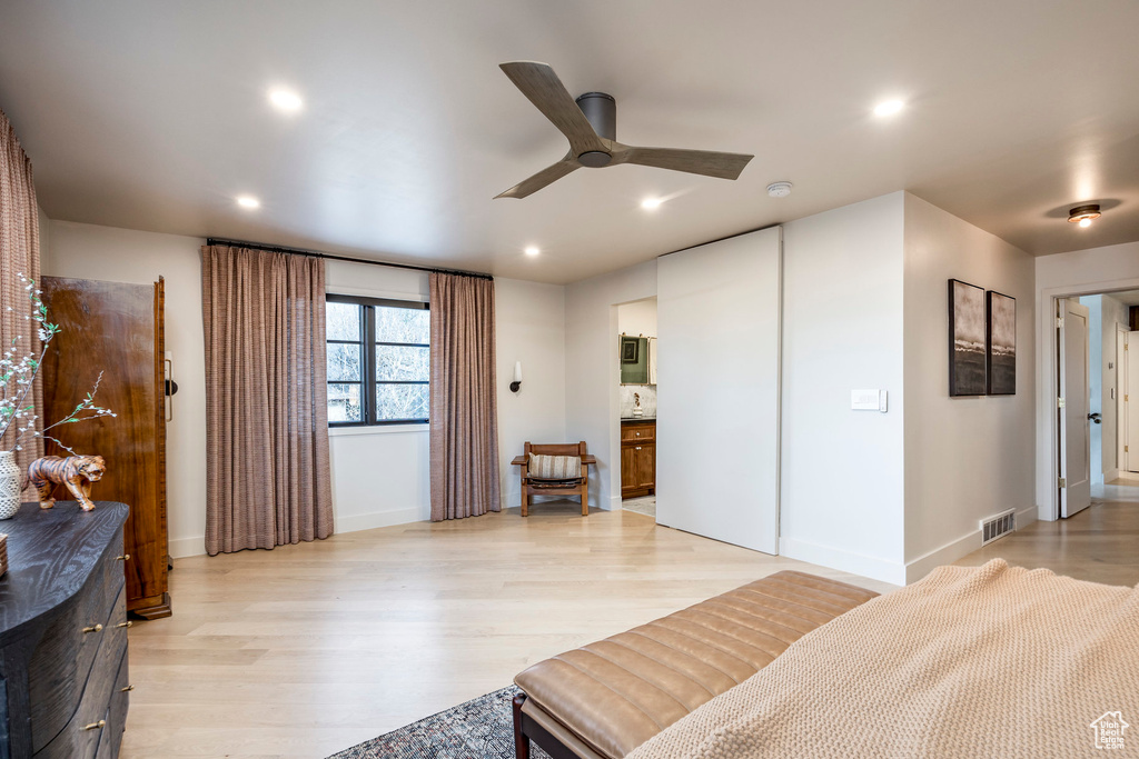 Bedroom with light wood-style flooring, recessed lighting, baseboards, and connected bathroom