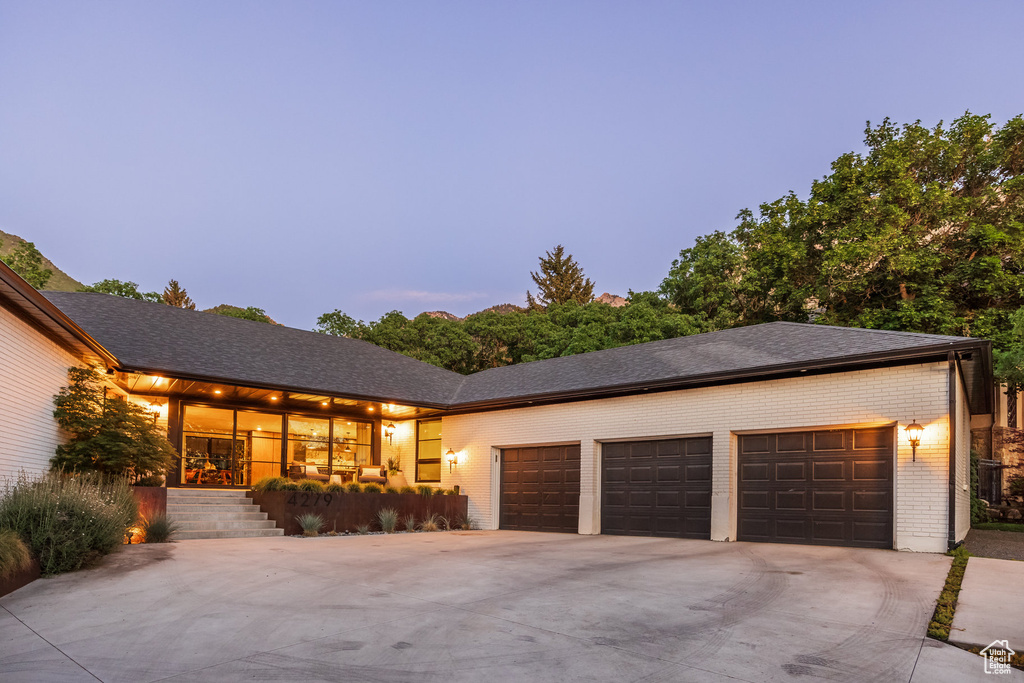 View of front facade featuring concrete driveway, a garage, and brick siding
