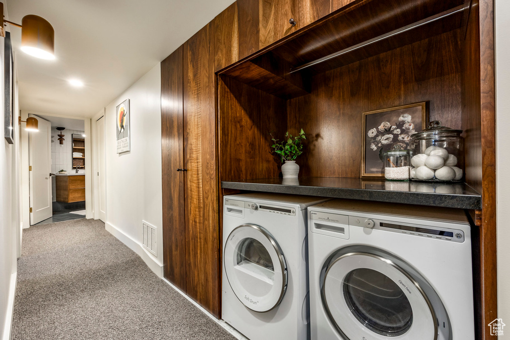 Washroom featuring washer and dryer, carpet, and baseboards