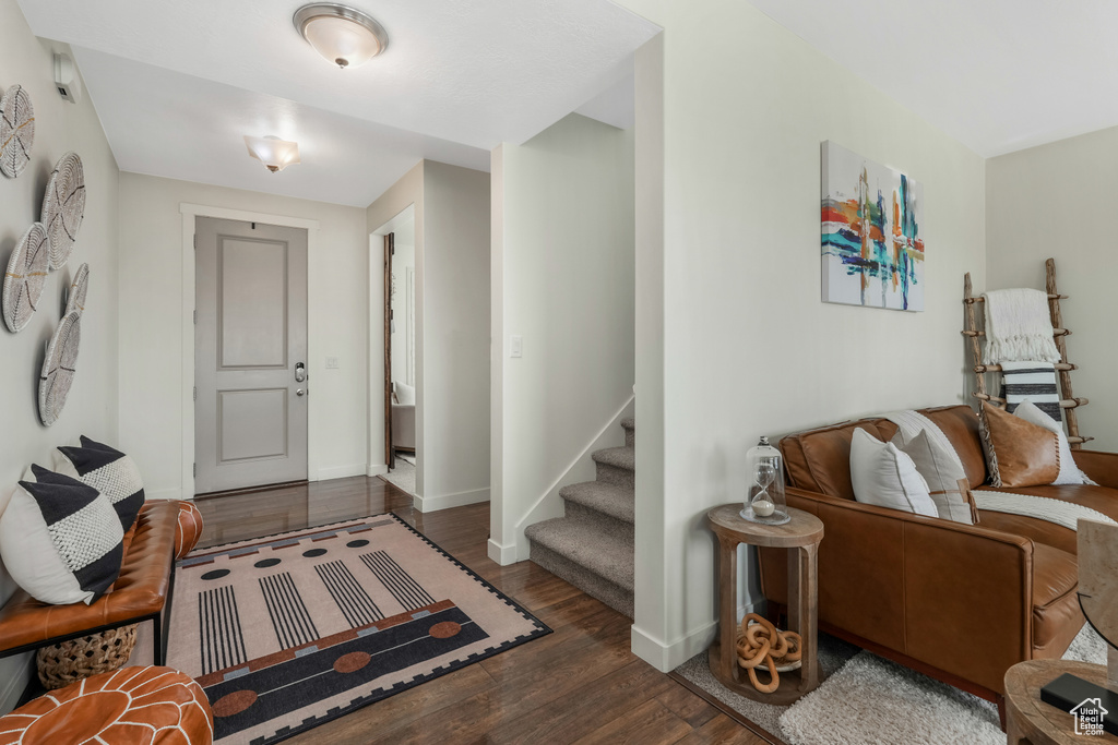 Foyer entrance with wood finished floors, baseboards, and stairs