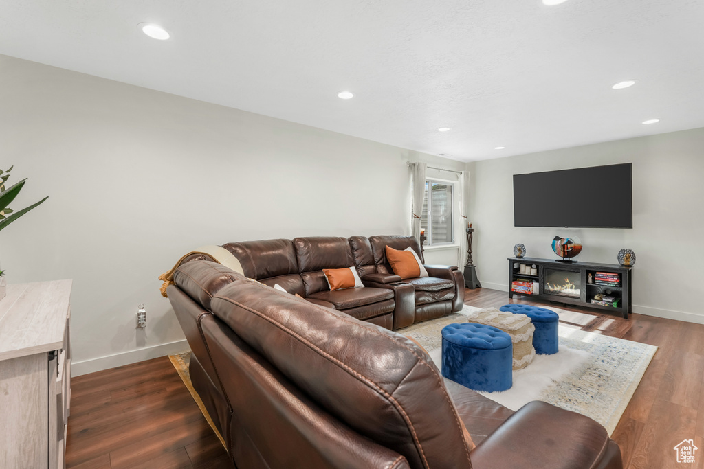 Living room with baseboards, recessed lighting, and dark wood-style floors