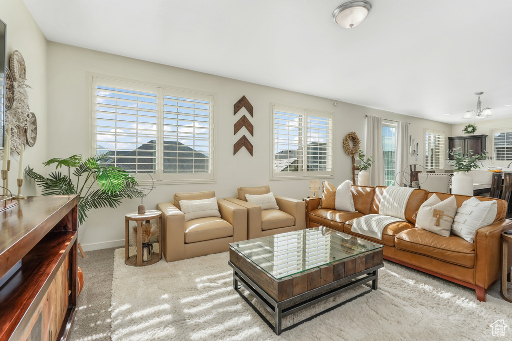 Living area with carpet, baseboards, and a chandelier
