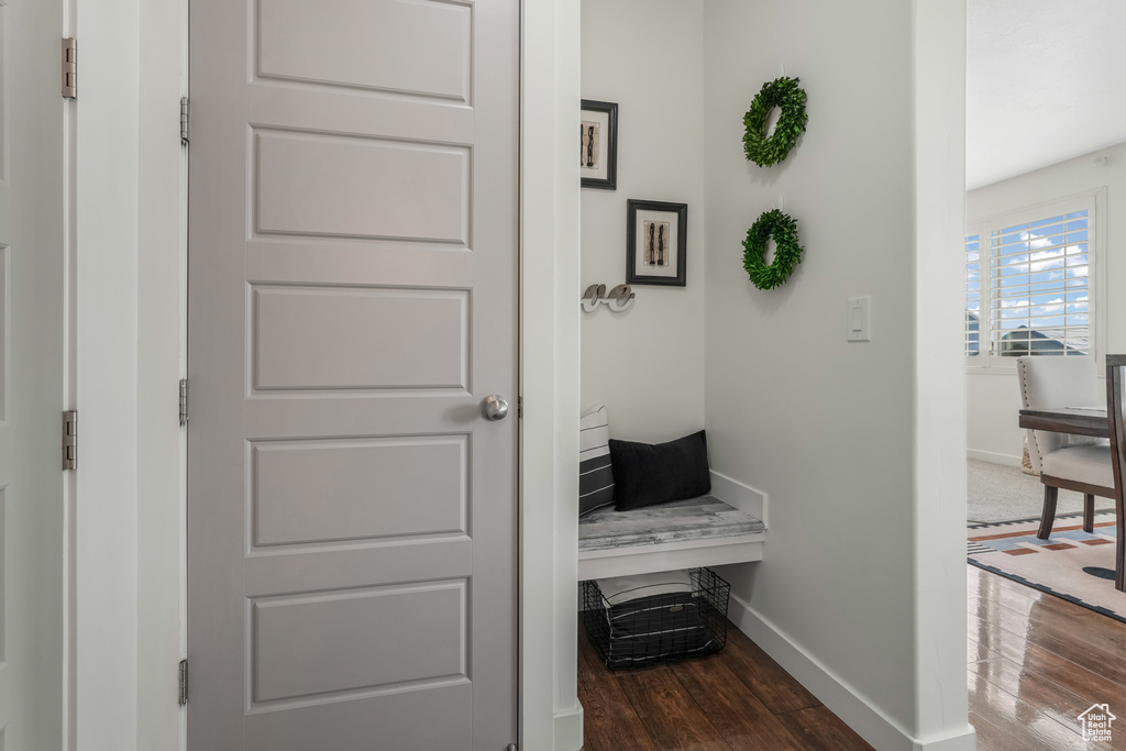 Corridor featuring dark wood-style flooring and baseboards