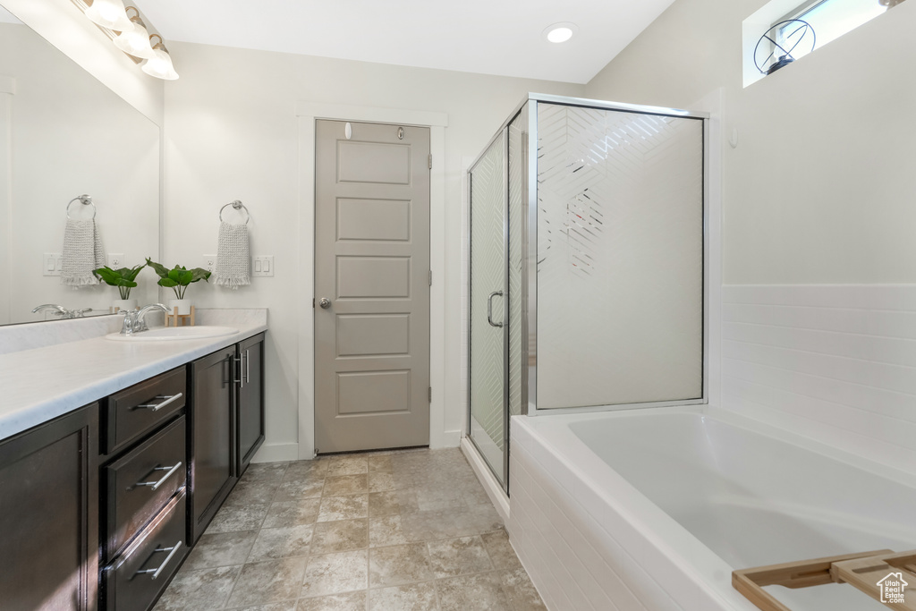Bathroom with vanity, a garden tub, and a shower stall