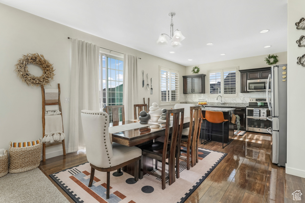Dining area featuring a chandelier, dark wood finished floors, and recessed lighting