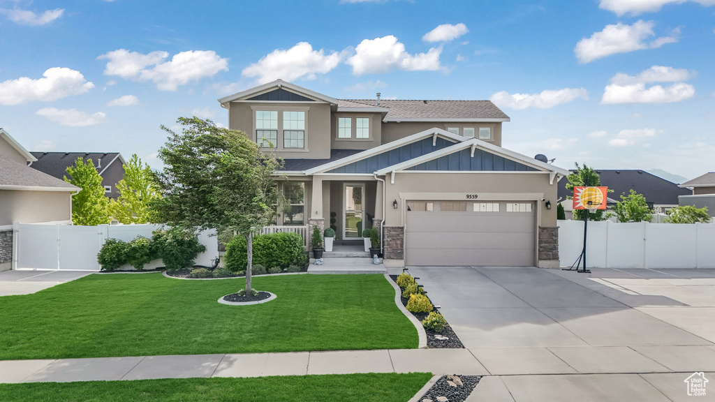 Craftsman-style house featuring a gate, stone siding, an attached garage, concrete driveway, and board and batten siding