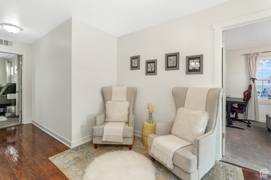 Sitting room with dark wood-style floors, baseboards, and an office area