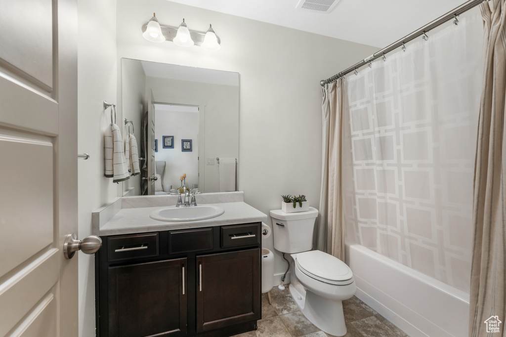 Full bathroom featuring toilet, vanity, and shower / tub combo