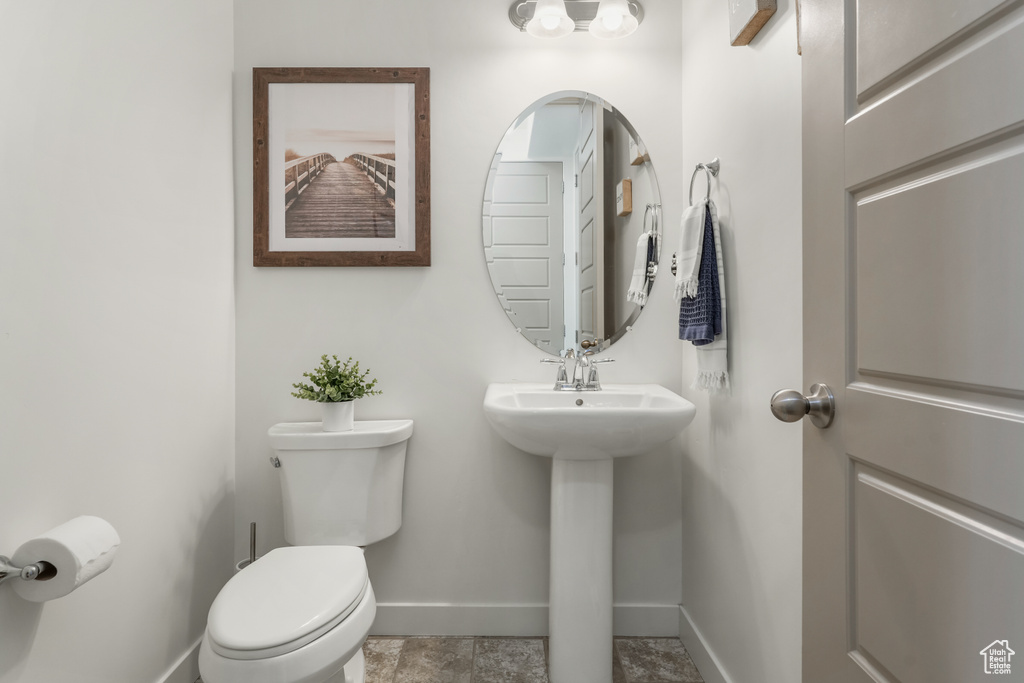 Bathroom featuring baseboards and toilet