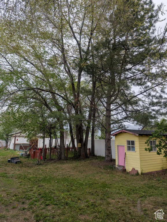 View of yard featuring fence and an outbuilding