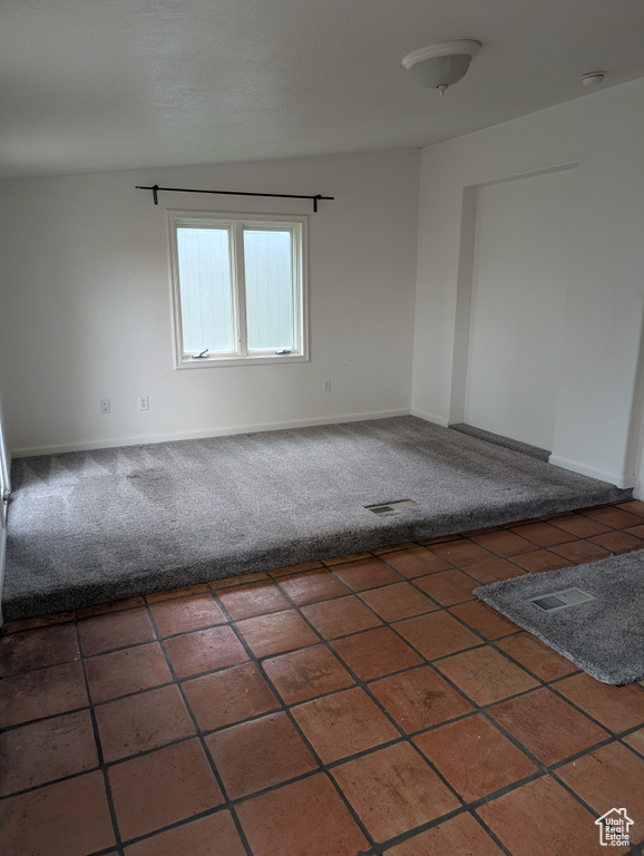 Carpeted spare room featuring baseboards and a smoke detector