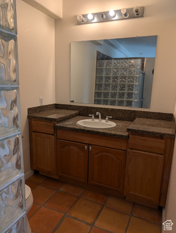 Bathroom featuring vanity, toilet, and tile patterned flooring
