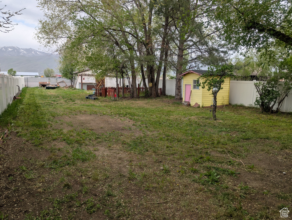 View of yard featuring a mountain view and an outbuilding