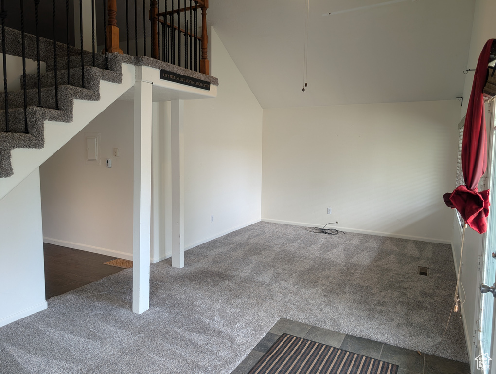 Staircase featuring carpet flooring, lofted ceiling, and baseboards