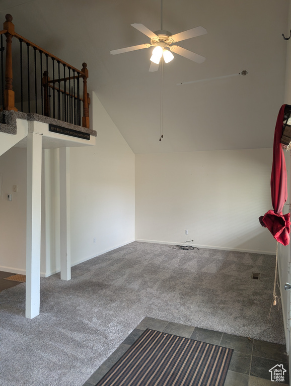 Unfurnished living room with carpet, ceiling fan, lofted ceiling, and baseboards