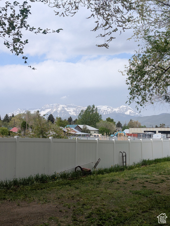 View of yard with a mountain view and fence