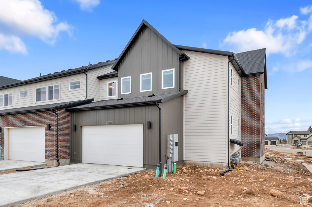 Back of house featuring a garage and concrete driveway