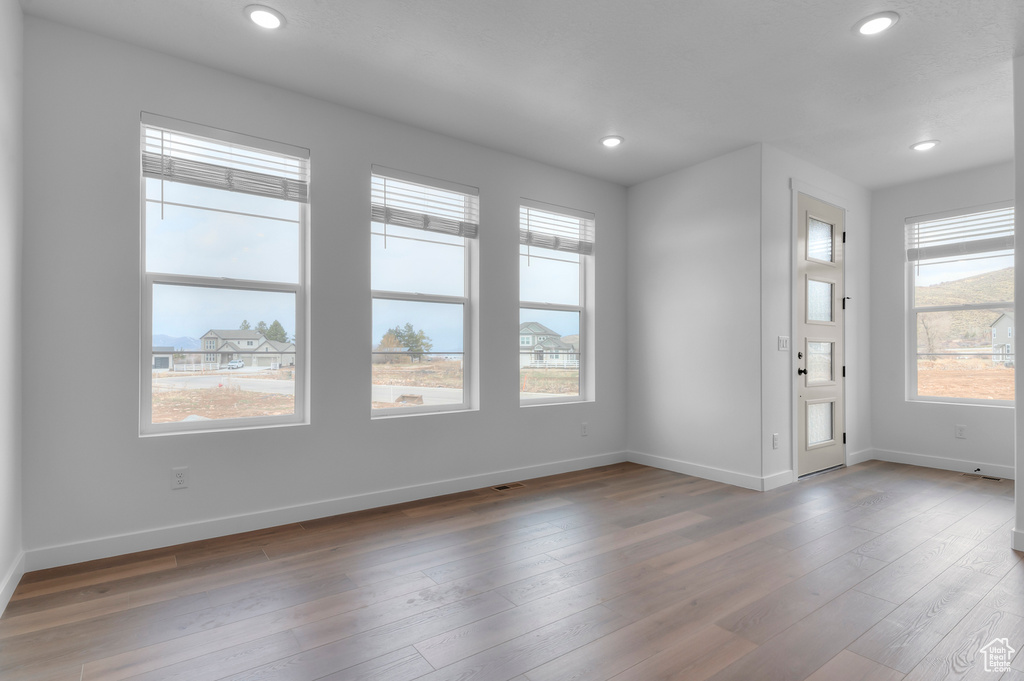 Foyer featuring baseboards, plenty of natural light, recessed lighting, and wood finished floors