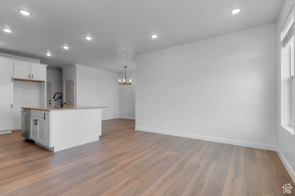 Kitchen with a chandelier, recessed lighting, light wood-style floors, white cabinetry, and baseboards