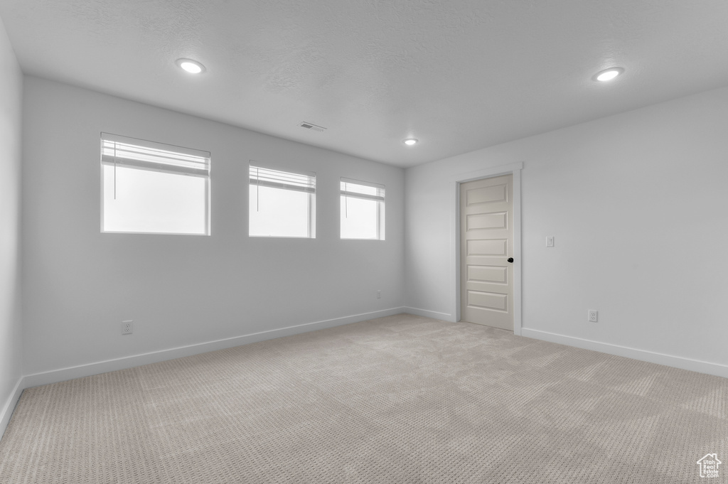 Unfurnished room with baseboards, light colored carpet, and recessed lighting