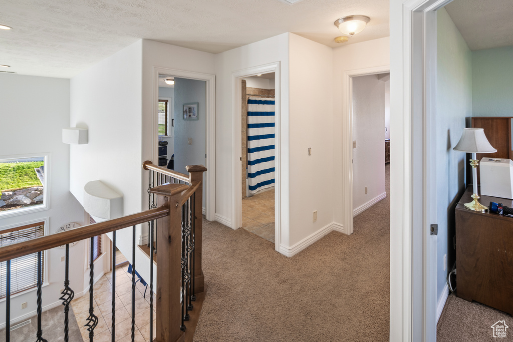 Hall featuring an upstairs landing, carpet, and baseboards