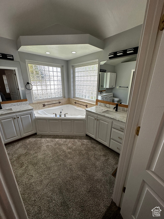 Bathroom featuring vanity, a garden tub, and recessed lighting