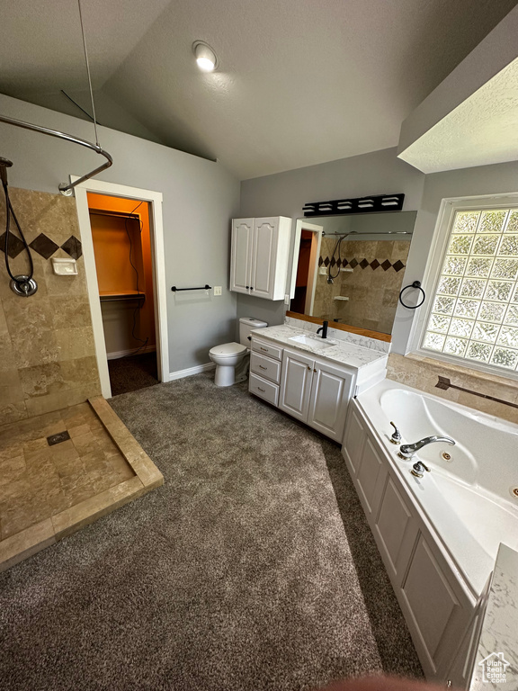 Full bathroom with vaulted ceiling, a tile shower, a jetted tub, vanity, and toilet