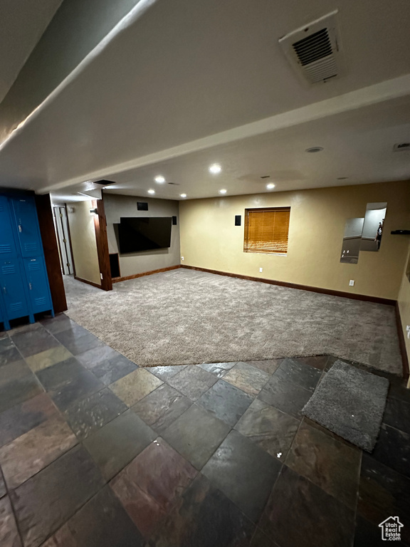 Finished basement with baseboards, stone tile flooring, and recessed lighting