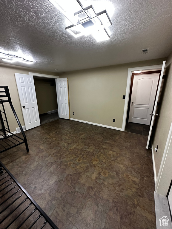 Finished basement with a textured ceiling and baseboards