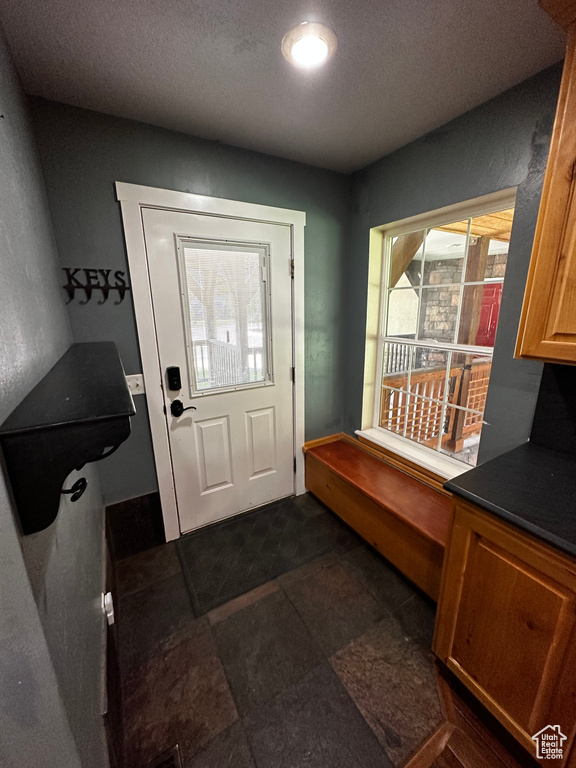 Doorway to outside with a textured ceiling