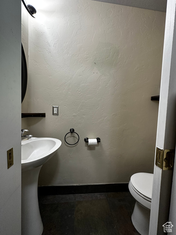 Bathroom with toilet and baseboards
