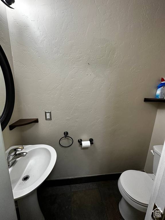 Bathroom with a sink, toilet, and baseboards