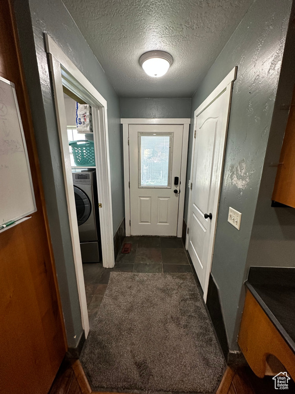 Doorway featuring washer / dryer and a textured ceiling