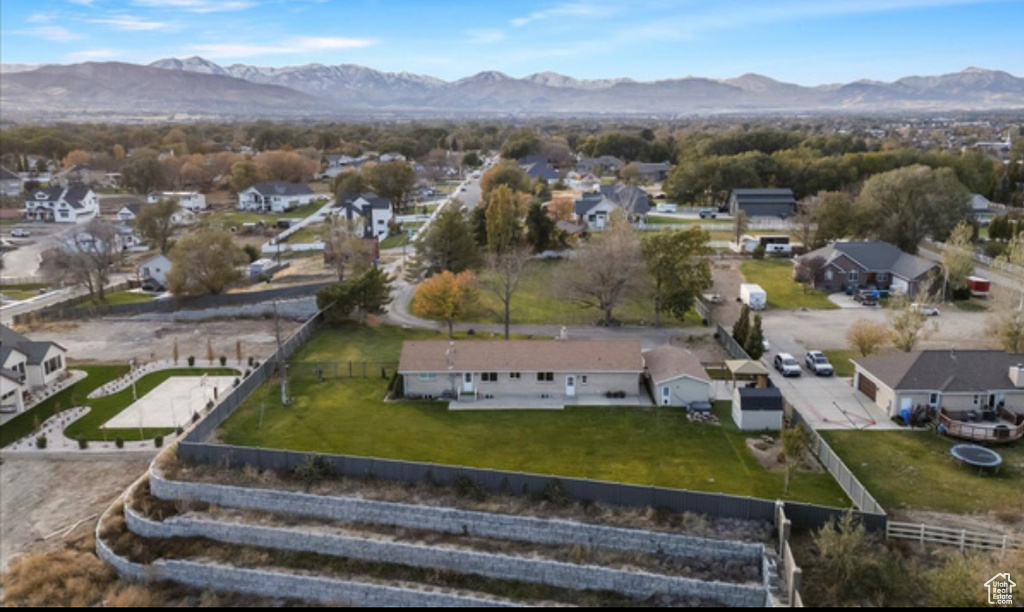 Aerial view of property and surrounding area featuring a mountainous background and nearby suburban area