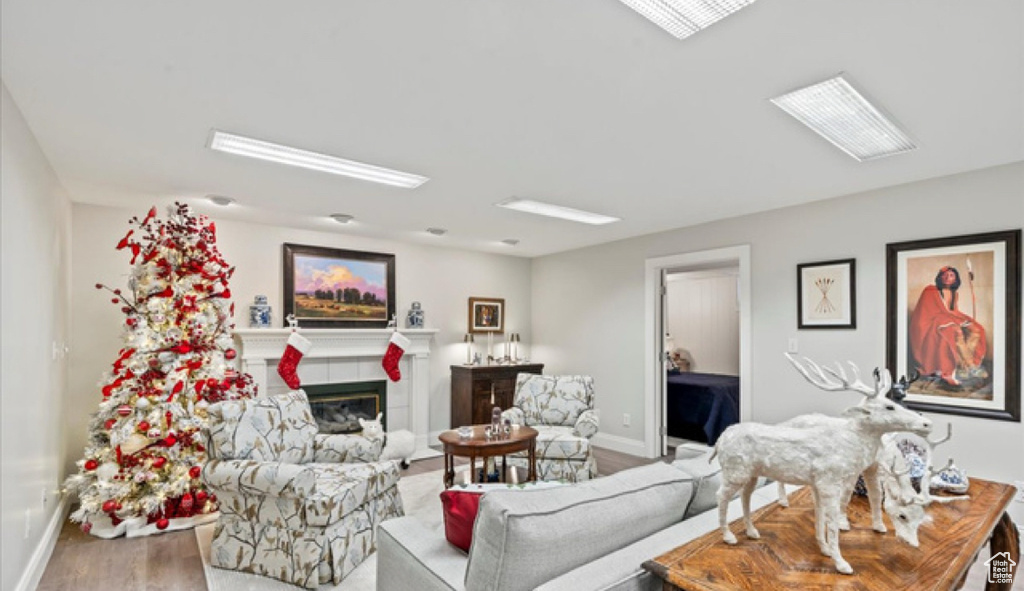 Living area with wood finished floors, a fireplace, and baseboards