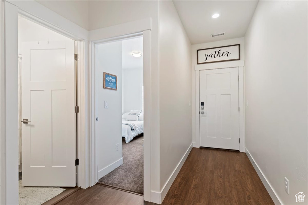 Hall featuring dark wood-style flooring and baseboards