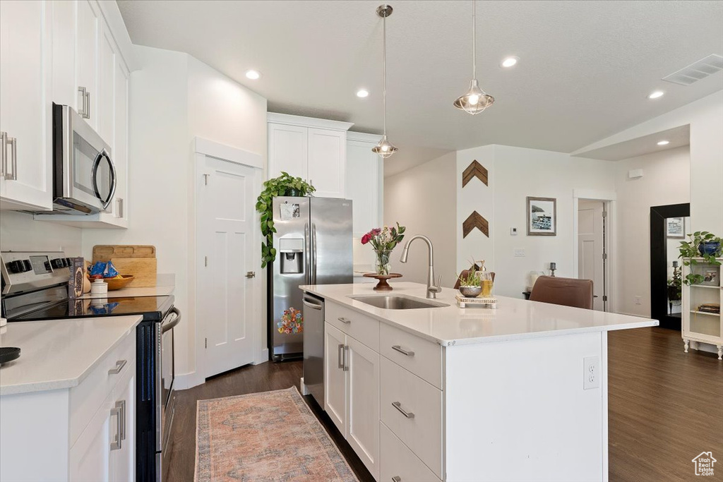 Kitchen featuring stainless steel appliances, a sink, dark wood-style flooring, white cabinets, and light countertops