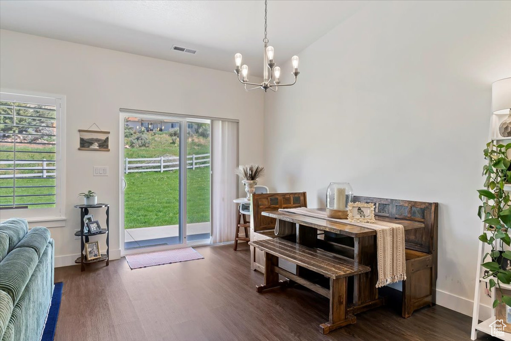 Dining room featuring a chandelier, dark wood-style flooring, and baseboards