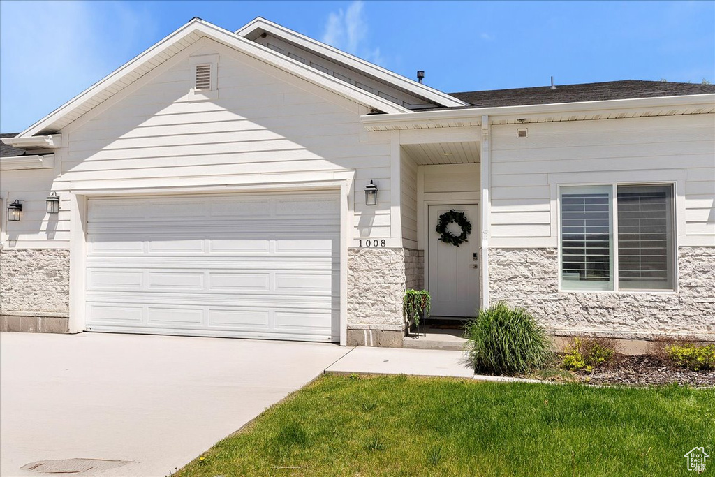 Single story home with concrete driveway, a garage, and roof with shingles