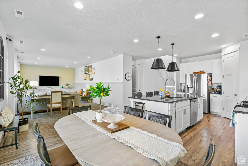 Dining space with light wood-type flooring and recessed lighting