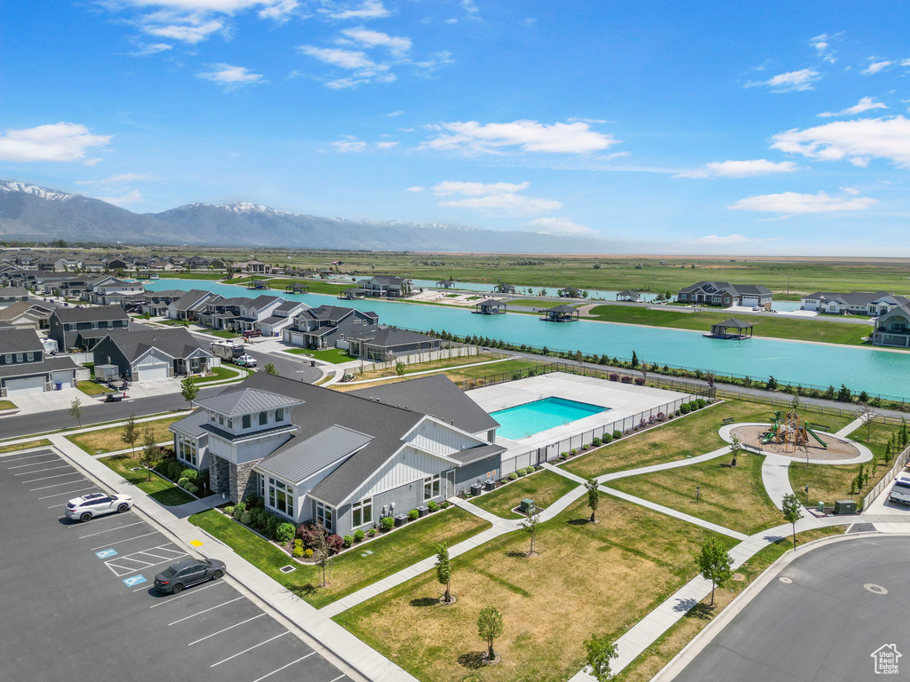 Aerial view of residential area with a nearby body of water and a pool